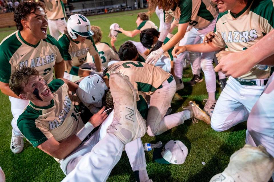 Timberline players dogpile on top of Gage Reeser after his walk-off single in the bottom of the seventh inning helped the Blazers beat Stadium, 7-6, in the 3A West Central/Southwest district baseball championship game at Auburn High School on Saturday, May 13, 2023, in Auburn, Wash.