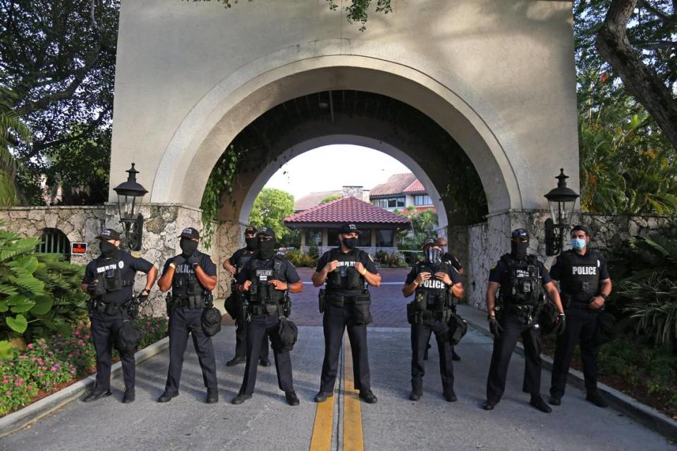 City of Miami police officers guard the entrance to the home of Miami-Dade State Attorney Katherine Fernández Rundle in Coconut Grove as protesters gather outside demanding her to drop all charges against Black Lives Matter demonstrators, including more than 100 demonstrators who have been arrested in the 70 days since George Floyd’s death, Tuesday, August 11, 2020.