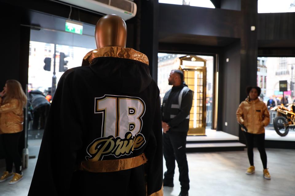 The back of a mannequin wearing a black robe that says "1B Prime."