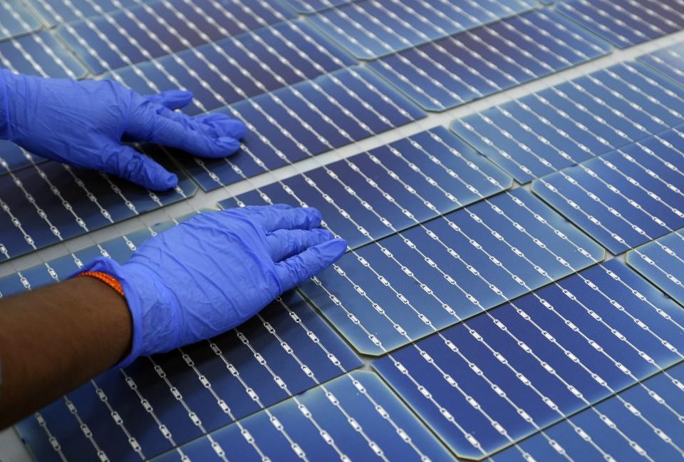 A worker makes arrangements of solar cells at Premier Energies Solar on the outskirts of Hyderabad, India, Wednesday, Jan. 25, 2023. Solar developers in India fear that a tax meant to encourage Indian manufacture of solar components will slow down the installation of solar power this year. (AP Photo/Mahesh Kumar A.)