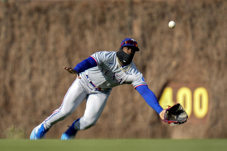 Texas Rangers right fielder Adolis Garcia misses a hit from Chicago Cubs second baseman Nico Hoerner during the sixth inning of a baseball game Saturday, April 8, 2023, in Chicago. (AP Photo/Erin Hooley)