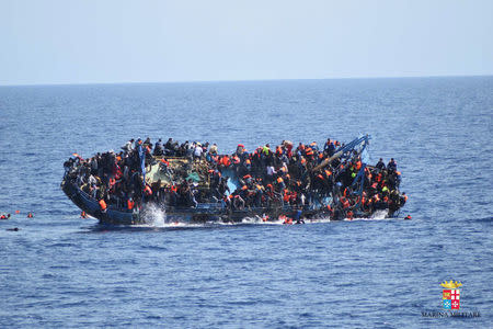 Migrants are seen on a capsizing boat before a rescue operation by Italian navy ships "Bettica" and "Bergamini" (unseen) off the coast of Libya in this handout picture released by the Italian Marina Militare on May 25, 2016. Marina Militare/Handout via REUTERS