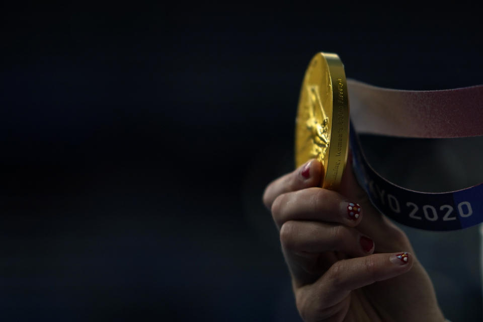 Kathleen Ledecky, of United States, shows her gold medal after winning the women's 800-meter freestyle final at the 2020 Summer Olympics, Saturday, July 31, 2021, in Tokyo, Japan. (AP Photo/David Goldman)