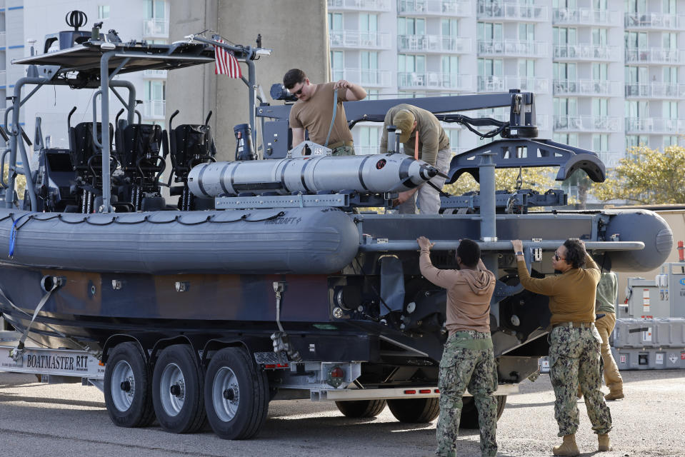 Members of the Navy work on a device on a vessel along the InterCoastal Waterway in North Myrtle Beach, S.C., Tuesday, Feb. 7, 2023. Using underwater drones, warships and inflatable vessels, the Navy is carrying out an extensive operation to gather all of the pieces of the massive Chinese spy balloon a U.S. fighter jet shot down off the coast of South Carolina on Saturday. (AP Photo/Nell Redmond)