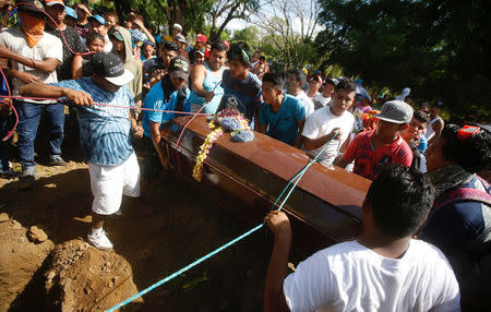 Relatives and friends stand beside Jairo Hernandez's casket during his funeral at the cemetery in Masaya, who according to the nation's Red Cross was shot dead during a protest over a controversial reform to the pension plans of the Nicaraguan Social Security Institute (INSS) in Nicaragua April 21, 2018. REUTERS/Jorge Cabrera