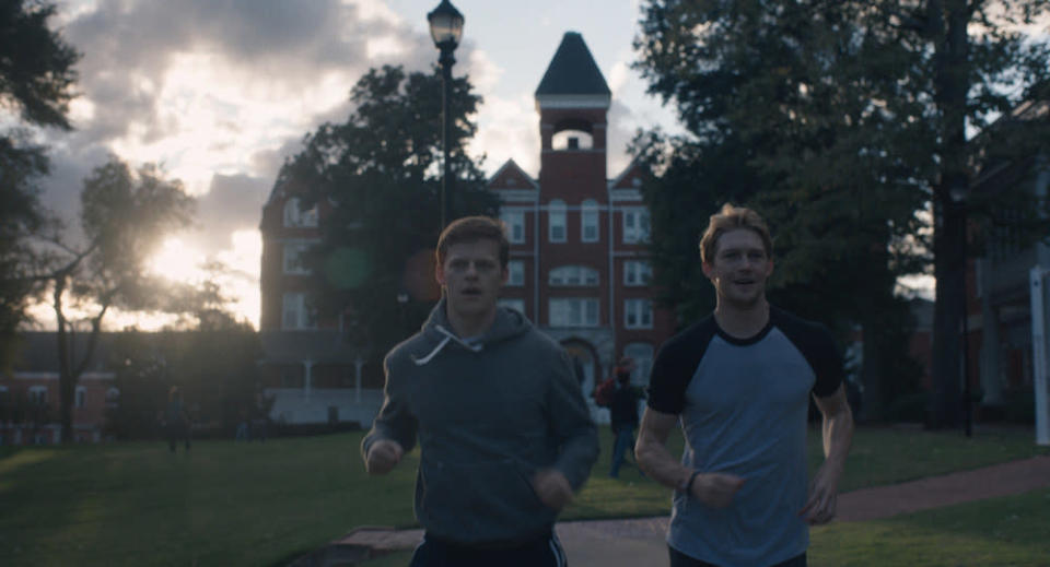 Joe Alwyn and Lucas Hedges run on a college campus.
