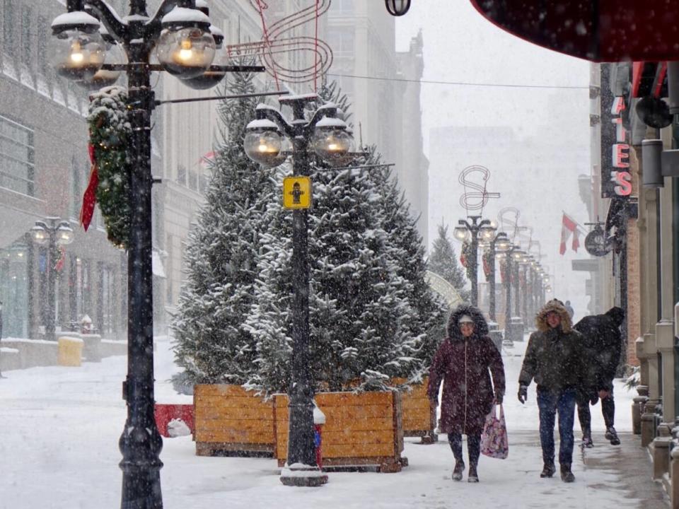 People walk down Sparks Streets during Saturday's snowy weather. On Sunday, health officials in Ottawa reported another 55 cases of COVID-19.  (Joseph Tunney/CBC - image credit)