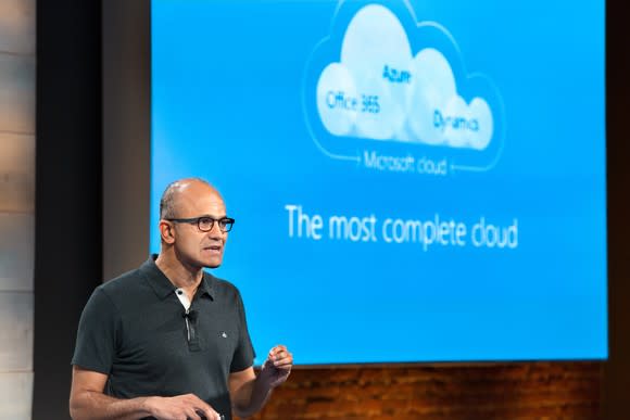 Satya Nadella in front of a presentation about Microsoft's 