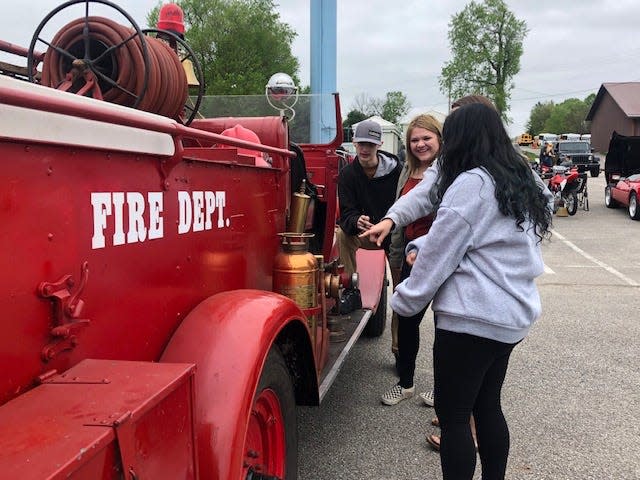 Gateway Academy students Gavin Blackshear, Justice Thomas and Isabel Morales check out the 1929 fire engine at the North Lawrence Career Center car show Wednesday. Also pictured is Kylee Jones, Gateway staff member.