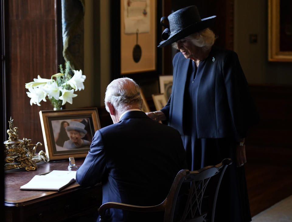 FILE - Crowds cheer as King Charles III and Camilla, the Queen Consort sign the visitors book during a visit to Hillsborough Castle, Belfast, Tuesday, Sept. 13. 2022. (Niall Carson/Pool photo via AP, File)