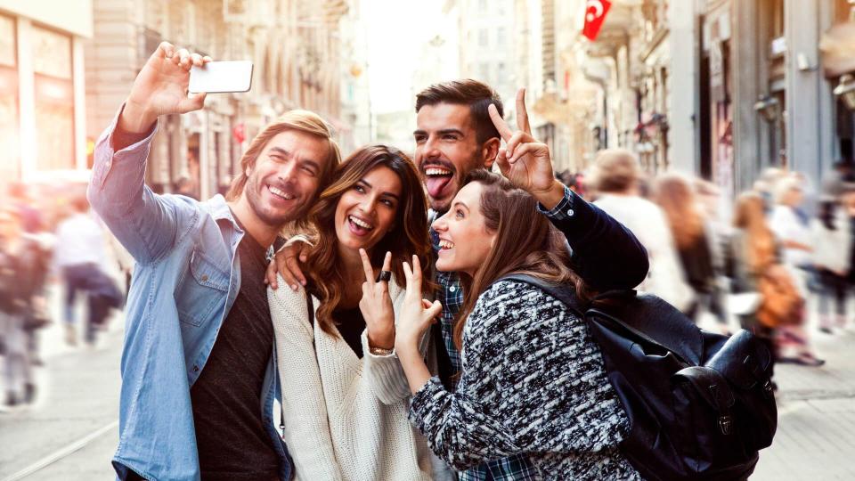 Happy friends taking a selfie in the city