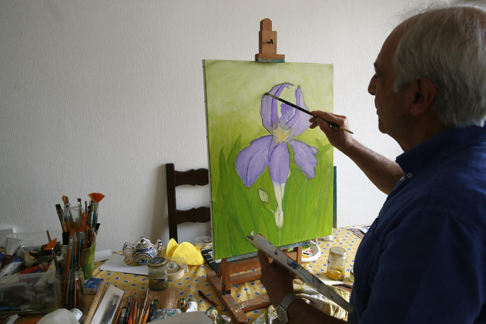 In this photo taken Friday June 5, 2020, Gilbert Haiun, brother of Monette Hayoun, and Dr Robert Haiun poses with his painting project during an interview in Ivry sur Seine, south of Paris. His brother Meyer Haiun died on March 26 in a Paris home managed by a 200-year-old Jewish charitable foundation. Families whose elders died behind the closed doors of homes in lockdown are filing wrongful death lawsuits, triggering police investigations. (AP Photo/Francois Mori)