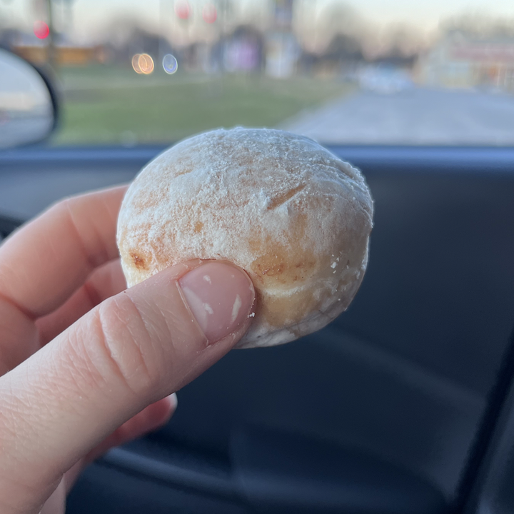 I hold a hazelnut-filled McPop in my hand, which is a mini powdered donut.