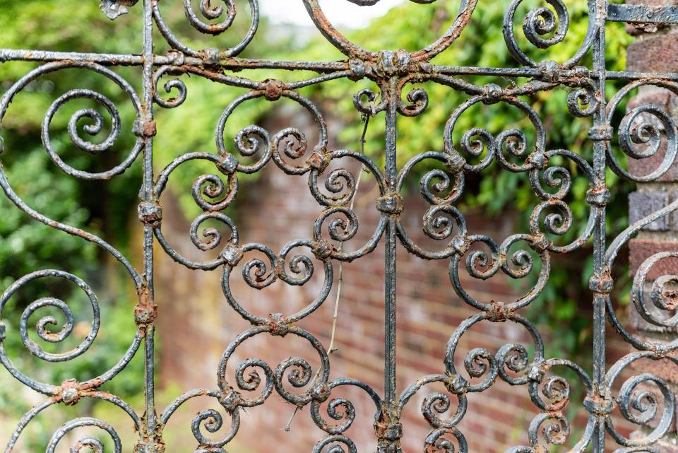 Filigreed wrought iron garden gate is an original feature.