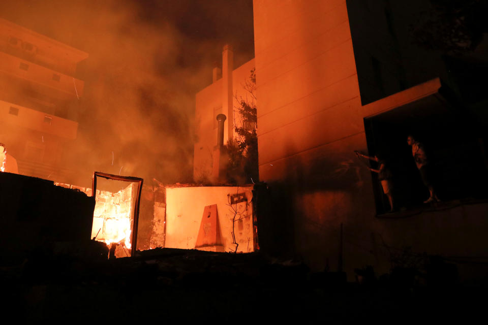 <p>Locals try to extinguish a fire at a nearby house as a wildfire burns at the village of Mati, near Athens, Greece, July 23, 2018. (Photo: Alkis Konstantinidis/Reuters) </p>