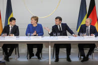 Ukraine's President Volodymyr Zelenskiy, left, German Chancellor Angela Merkel, French President Emmanuel Macron and Russian President Vladimir Putin, right, attend a joint news conference at the Elysee Palace in Paris, Monday Dec. 9, 2019. Russian President Vladimir Putin and Ukrainian President Volodymyr Zelenskiy met for the first time Monday at a summit in Paris to try to end five years of war between Ukrainian troops and Russian-backed separatists. (Ludovic Marin/Pool via AP)