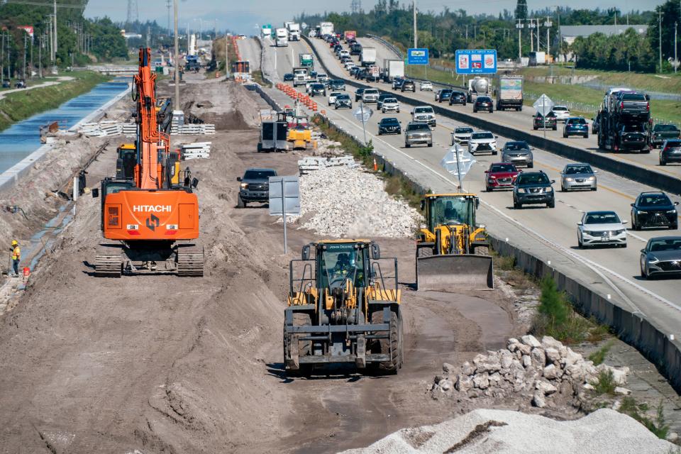 Construction crews work along the Florida Turnpike north of Hypoluxo Road on December 22, 2021. 