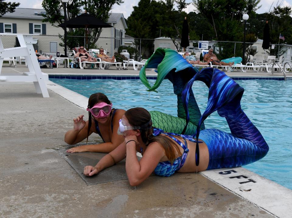 Tasha Haight, owner and head mermaid of Mermaid Tasha LLC, and Marilyn Wagner practice for a performance July 12, 2023, at Assateague Point in Berlin, Maryland.