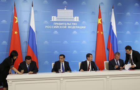 Russia's Prime Minister Dmitry Medvedev (3rd R), China's Premier Li Keqiang (3rd L), Rosneft President Igor Sechin (2nd R) and CNPC Vice-President Wang Dongjin (2nd L) attend a signing ceremony in Moscow, October 13, 2014. REUTERS/Yekaterina Shtukina/RIA Novosti/Pool