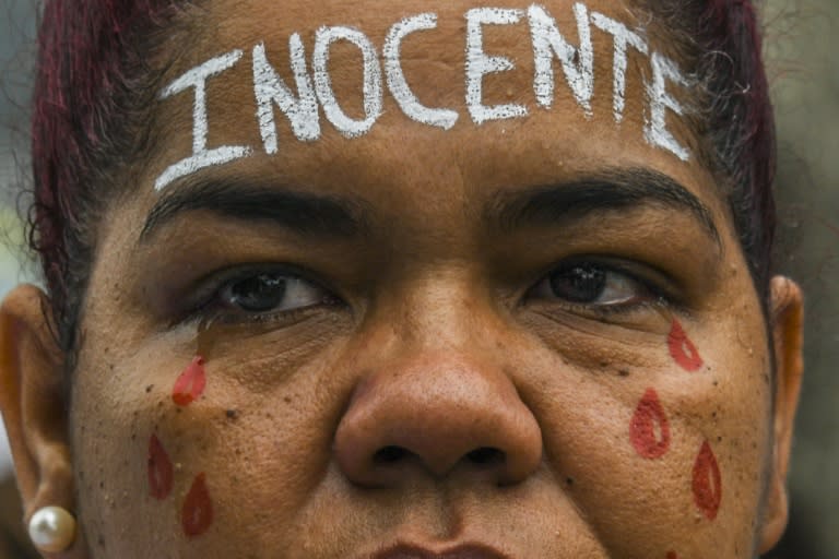 A woman with the word "Innocent" written on her forehead takes part in a demonstration by residents of two Rio favelas demanding peace -- the army fanned out again Monday to back up police in the area wracked by violence