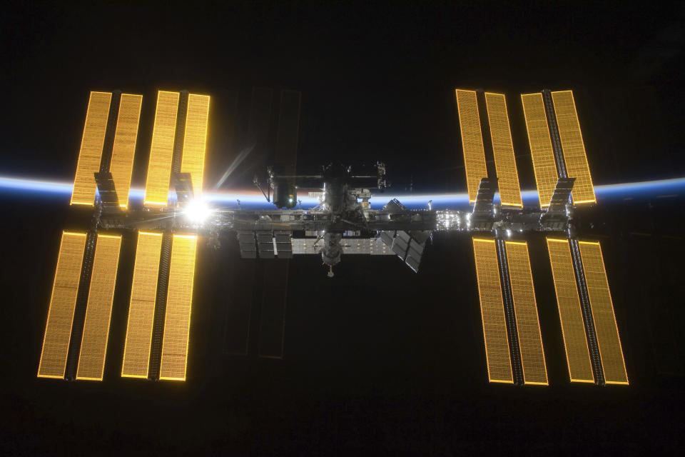 This March 25, 2009 photo provided by NASA shows the International Space Station seen from the Space Shuttle Discovery during separation. In the background is Earth's atmosphere seen as a blue arc. On Tuesday, April 30, 2019, NASA announced that a major power shortage at the station has delayed a SpaceX supply run later in the week. (NASA via AP)