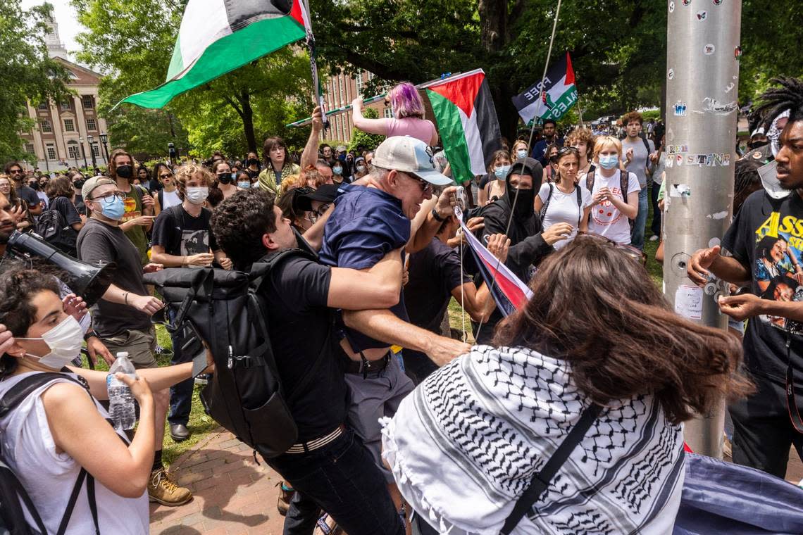 Pro-Palestinian demonstrators struggle with a counter-protester as Pro-Palestinian demonstrators replace an American flag with a Palestinian flag Tuesday, April 30, 2024 at UNC-Chapel Hill. Police removed a “Gaza solidarity encampment” earlier Tuesday morning.