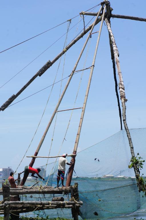 Indian fishermen work on Chinese fishing nets in Kochi, in southern Kerala state, September 13, 2014