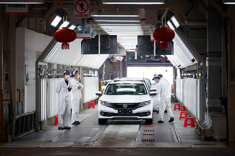 Employees work on a production line inside a Dongfeng Honda factory in Wuhan