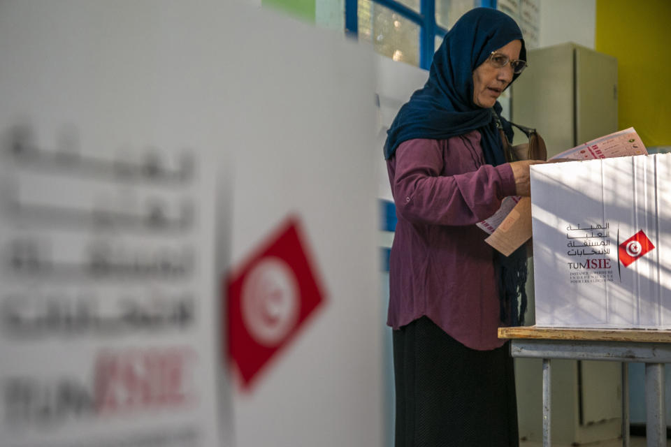 A voter casts her ballot inside a polling station during a parliamentary election in La Marsa, outside Tunis, Tunisia, Sunday, Oct. 6, 2019. Tunisians were electing a new parliament Sunday amid a tumultuous political season, with a moderate Islamist party and a jailed tycoon's populist movement vying to come out on top of a crowded field. (AP Photo/Riadh Dridi)
