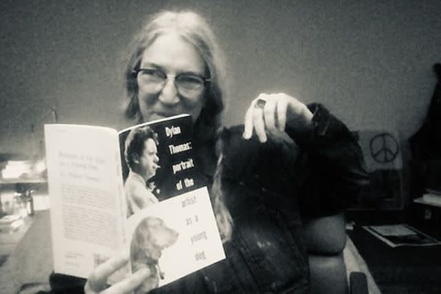 <p>Instagram/thisispattismith</p> Patti Smith smiles while reading a book on Dylan Thomas in a new Instagram post thanking Taylor Swift