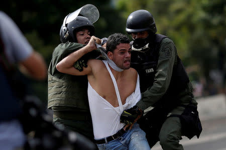 FILE PHOTO: A demonstrator is detained at a rally during a strike called to protest against Venezuelan President Nicolas Maduro's government in Caracas, Venezuela, July 27, 2017 . REUTERS/Ueslei Marcelino/File Photo
