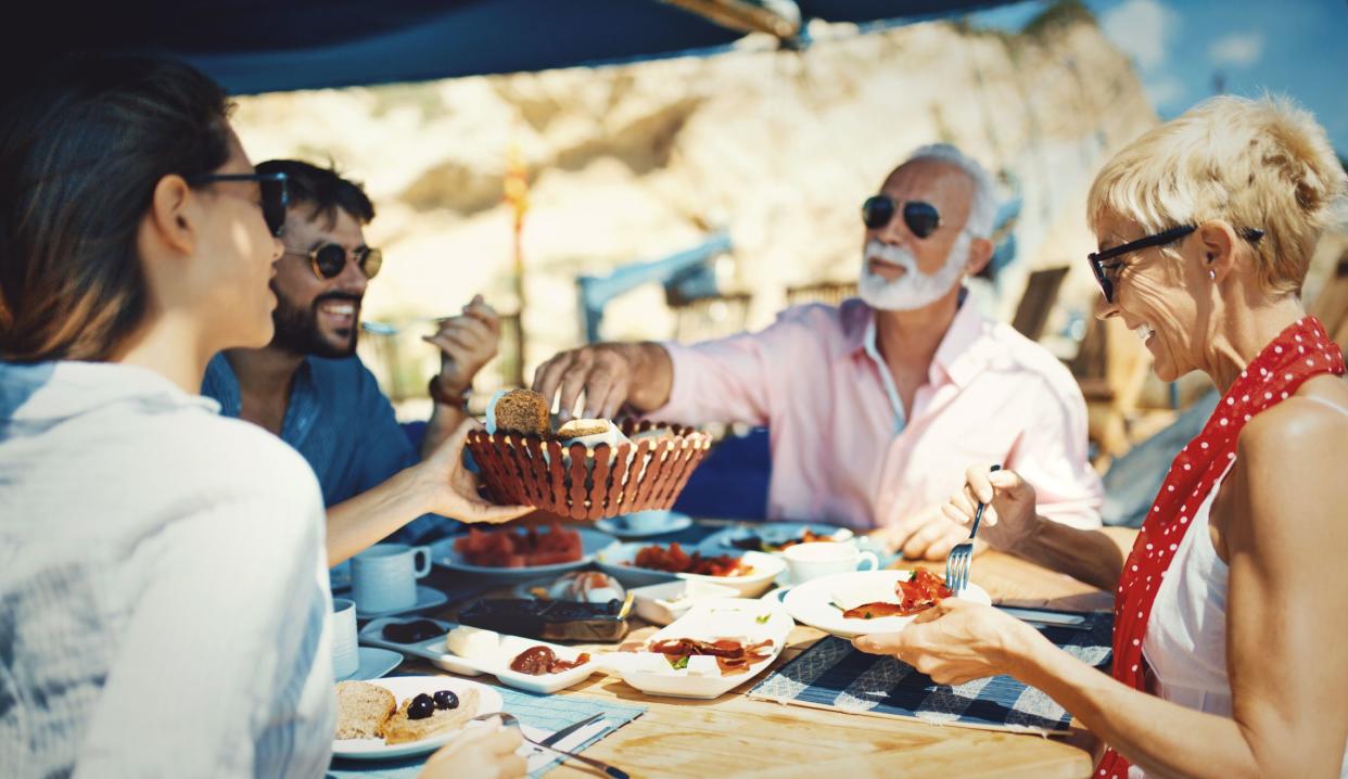 Family having breakfast on the sailing boat. They are eating and talking and enjoying the atmosphere that sea provides.