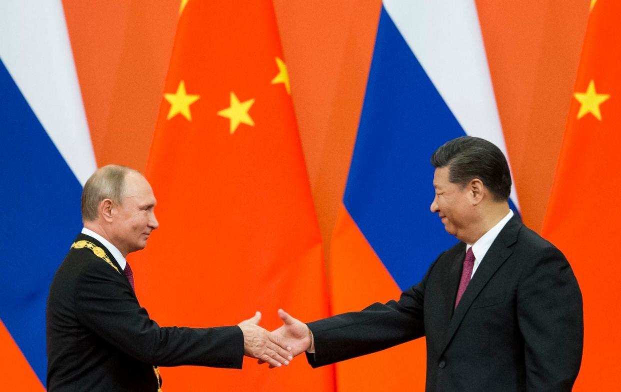 Chinese President Xi Jinping, right, and Russian President Vladimir Putin shake hands during an awarding ceremony at the Great Hall of the People in Beijing, China, on June 8, 2018. Xi is keeping the West guessing about whether Beijing will cooperate with tougher sanctions on Russia as he meets President Vladimir Putin a year after declaring they had a â€œno limitsâ€ friendship ahead of the Kremlinâ€™s invasion of Ukraine. - Alexander Zemlianichenko/Pool AP