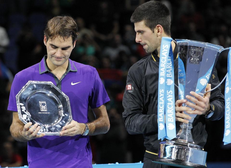 Novak Djokovic, right, of Serbia holds the winners ATP World Tour tennis trophy as he stand next to runner-up Roger Federer of Switzerland as they pose for the photographers following their singles final match in London, Monday, Nov. 12, 2012. (AP Photo/Sang Tan)