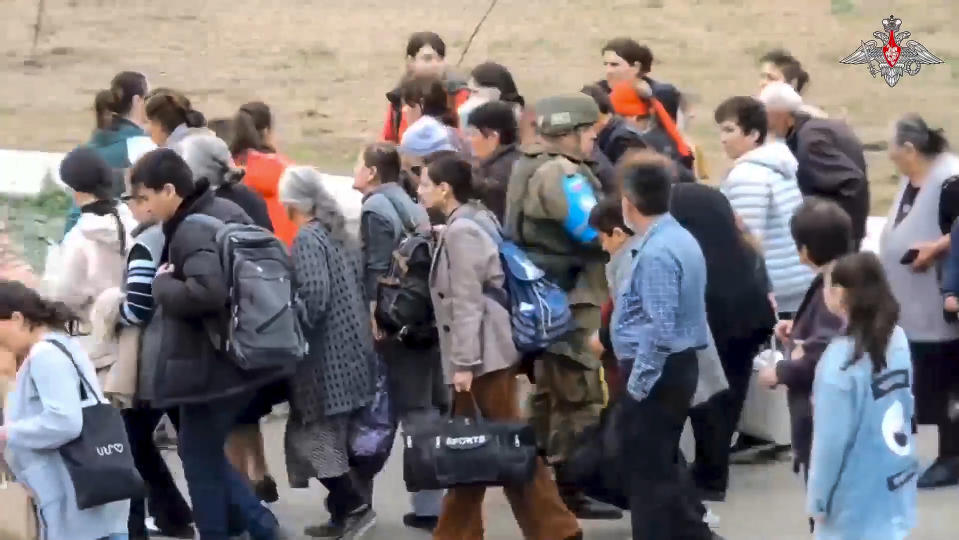 In this photo taken from video released by Russian Defense Ministry Press Service on Thursday, Sept. 21, 2023, Ethnic Armenians arrive at a Russian peacekeepers' camp near Stepanakert in Nagorno-Karabakh. Thousands of Nagorno-Karabakh residents flocked to a camp operated by Russian peacekeepers to avoid the fighting, while many others gathered at the airport of the regional capital, Stepanakert, hoping to flee the region. (Russian Defense Ministry Press Service via AP)