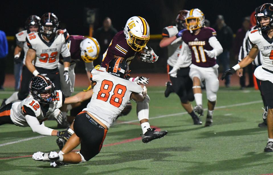 Simi Valley's Brice Hawkins tries to break away from Huntington Beach's Nathan Dumesnil during the Pioneers' 32-29 win in a CIF-SS Division 6 semifinal game on Friday, Nov. 17, 2023, at Simi Valley High.
