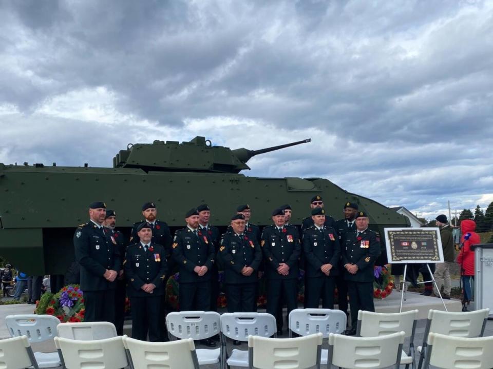 Members of the Canadian Armed Forces pose with the LAV III monument in CBS, commemorating the lives of those lost during the war in Afghanistan. (Nick Ward/CBC - image credit)