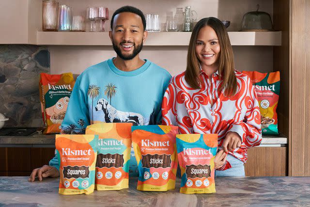 <p>Kismet</p> John Legend and Chrissy Teigen with Kismet's range of pet food products