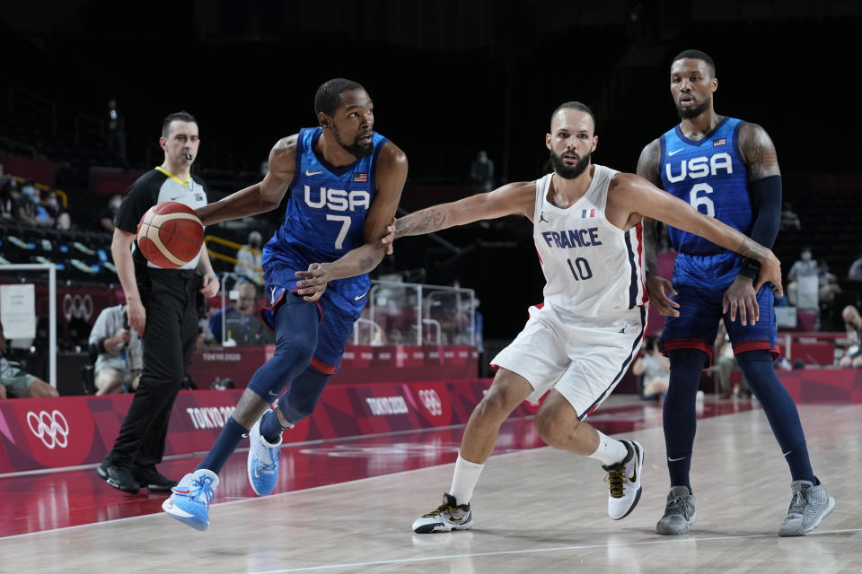 United States' forward Kevin Durant (7) drives around France's Evan Fournier (10) during a men's basketball preliminary round game at the 2020 Summer Olympics, Sunday, July 25, 2021, in Saitama, Japan. (AP Photo/Eric Gay)