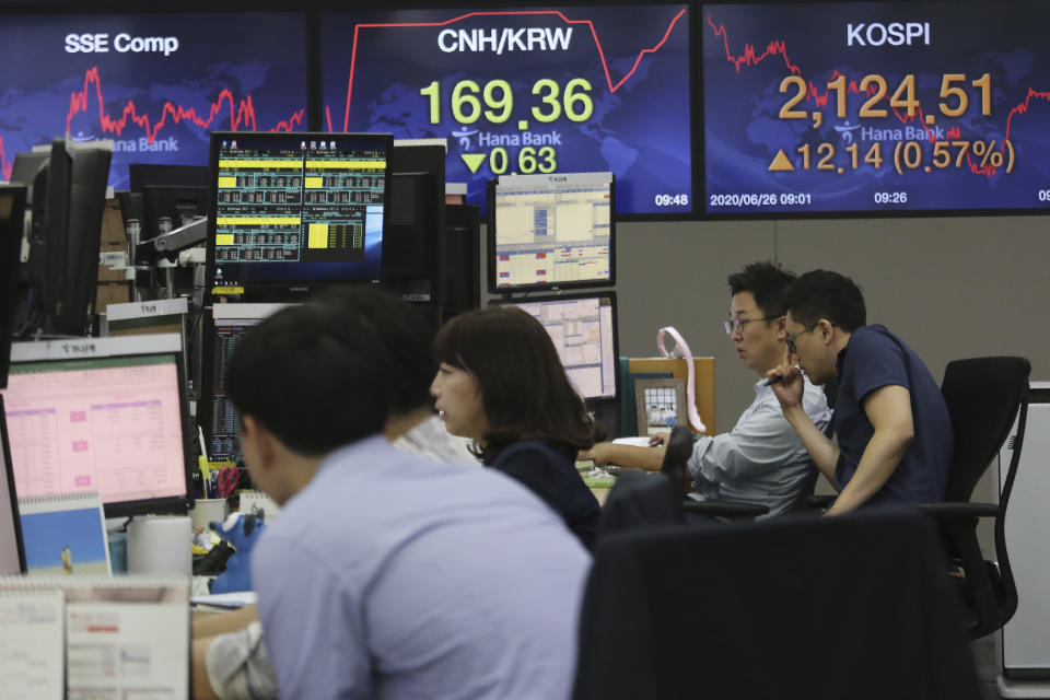 Currency traders watch monitors at the foreign exchange dealing room of the KEB Hana Bank headquarters in Seoul, South Korea, Friday, June 26, 2020. Asian stock markets followed Wall Street higher on Friday after U.S. regulators removed some limits on banks' ability to make investments. (AP Photo/Ahn Young-joon)