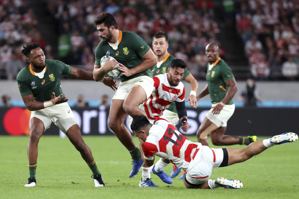 South Africa's Damian de Allende is tackled by Japan's Ryoto Nakamura (12) during the Rugby World Cup quarterfinal match at Tokyo Stadium in Tokyo, Japan, Sunday, Oct. 20, 2019. (AP Photo/Eugene Hoshiko)