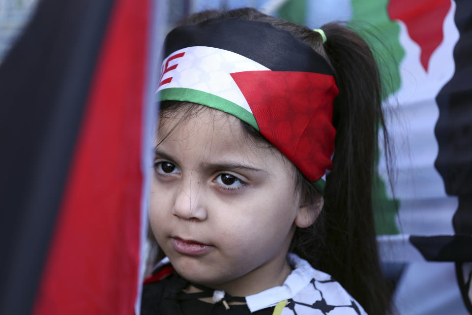 A Palestinian with a national flag on her head, attends a protest against the White House plan for ending the Israeli-Palestinian conflict, at Burj al-Barajneh refugee camp, south of Beirut, Lebanon, Friday, Jan. 31, 2020. (AP Photo/Bilal Hussein)