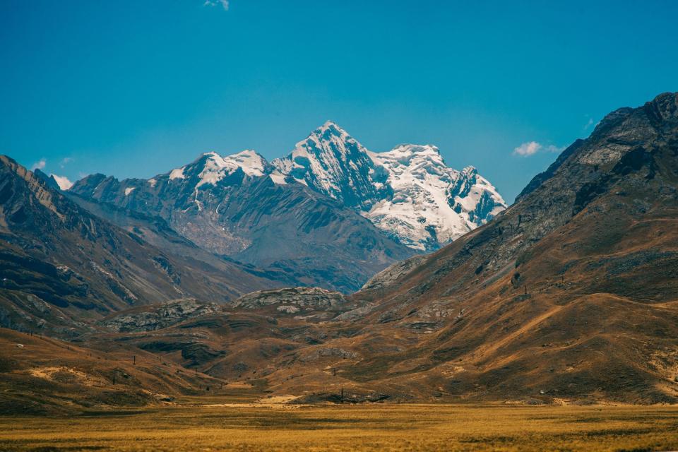 A photograph of the arid valley in front of Cordillera blanca, a glacial part of the Andes in Peru.