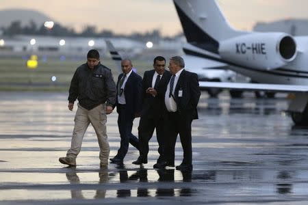 Federal agents walk on the tarmac after the arrival of Vicente Carrillo, drug kingpin of the Juarez Cartel, at the hangar belonging to the office of the Attorney's General in Mexico City October 9, 2014. Mexico captured the leader of the once-feared Juarez Cartel in the country's restive north on Thursday, the second drug kingpin to fall in just over a week, a government source said. Carrillo, 51, long-time head of the Juarez Cartel, was a fierce rival of Joaquin "Shorty" Guzman, the leader of the Sinaloa Cartel and the world's most wanted drug boss until his capture in February. REUTERS/Tomas Bravo (MEXICO - Tags: CRIME LAW CIVIL UNREST DRUGS SOCIETY POLITICS)