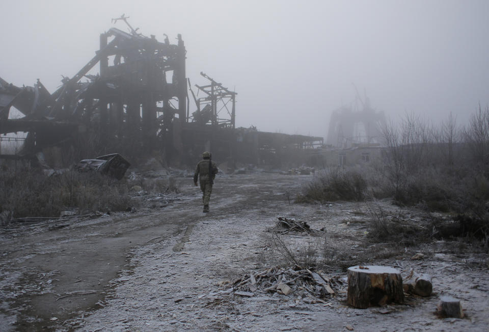 In this photo taken on Tuesday, Nov. 19, 2019, a Ukrainian soldier passes by a destroyed Butovka coal mine as he approaches his front line position in the town of Avdiivka in the Donetsk region, Ukraine. U.S.-made X-ray equipment, helmets and missiles make a difference for Ukrainian troops fighting Kremlin-backed separatists on the front line of the 21st century standoff between Russia and the West. (AP Photo/Vitali Komar)