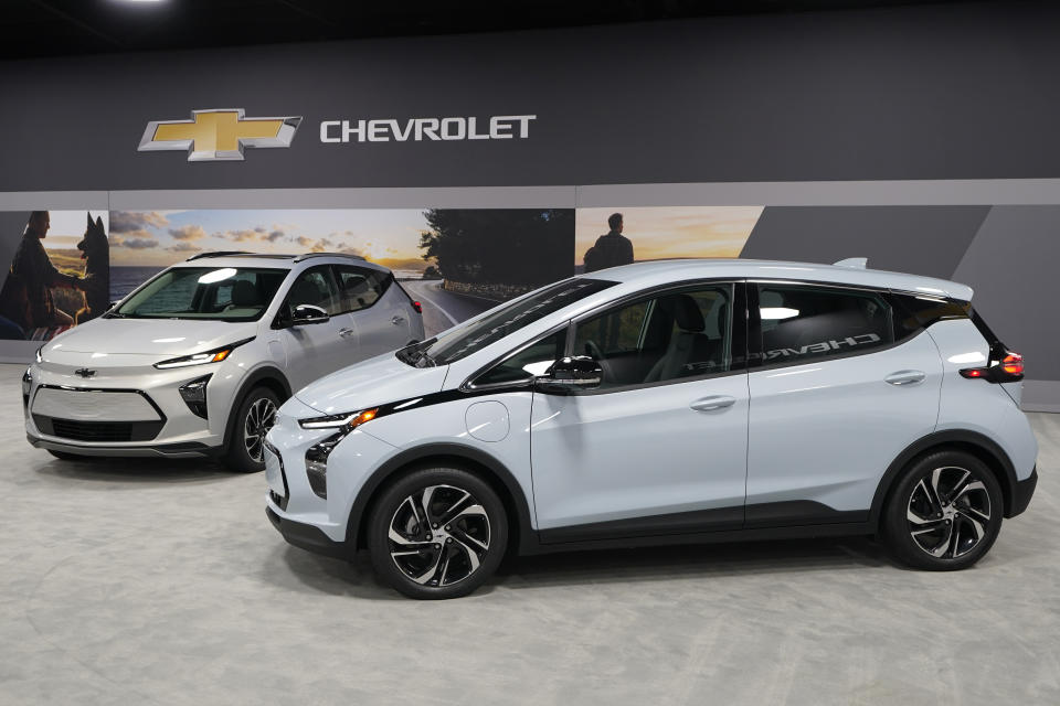 The 2022 Bolt EV, foreground, and EUV are displayed, Thursday, Feb. 11, 2021, in Milford, Mich. Whether people want them or not, automakers are rolling out multiple new electric vehicle models as the auto industry responds to stricter pollution regulations worldwide and calls to reduce emissions to fight climate change. (AP Photo/Carlos Osorio)