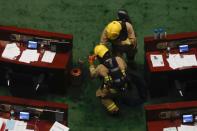 Firefighters check the chamber of the Legislative Council after pro-democracy lawmakers hurled objects during third reading on the controversial national anthem bill in Hong Kong