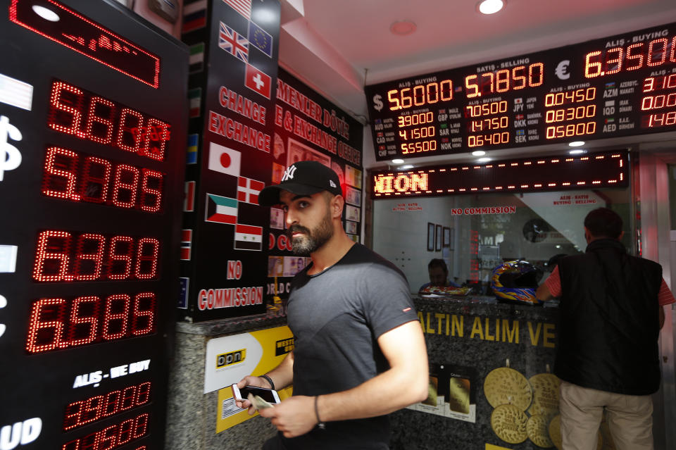 A man walks out of a currency exchange shop in Istanbul, Thursday, Aug. 16, 2018. Beset by a weak currency and tension with the United States, Turkey is reaching out to Europe in an attempt to shore up relations with major trading partners despite years of testy rhetoric and a stalled bid for EU membership. The overtures by Turkish President Recep Tayyip Erdogan, who has harshly criticized Germany and other European nations in the past, are part of a diplomatic campaign to capitalize on international unease over U.S. President Donald Trump and American tariff disputes. (AP Photo/Lefteris Pitarakis)