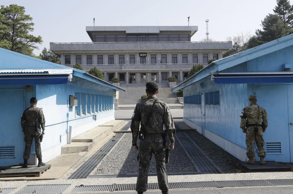 FILE - In this April 18, 2018 file photo, two South Korean soldiers, center and left, and U.S. soldier, right, stand in the southern side during a press tour at the border village of Panmunjom in the Demilitarized Zone, South Korea. North and South Korea and the U.S.-led United Nations Command on Tuesday, Oct. 16, 2018, are meeting to discuss efforts to disarm a military zone the rivals control within their shared border under a peace agreement between the Koreas. (AP Photo/Lee Jin-man, File)