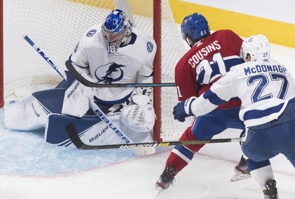 Montreal Canadiens' Nick Cousins (21) moves in on Tampa Bay Lightning goaltender Andrei Vasilevskiy as Lightning's Ryan McDonagh defends during the second period of an NHL hockey game Thursday, Jan. 2, 2020, in Montreal. (Graham Hughes/The Canadian Press via AP)